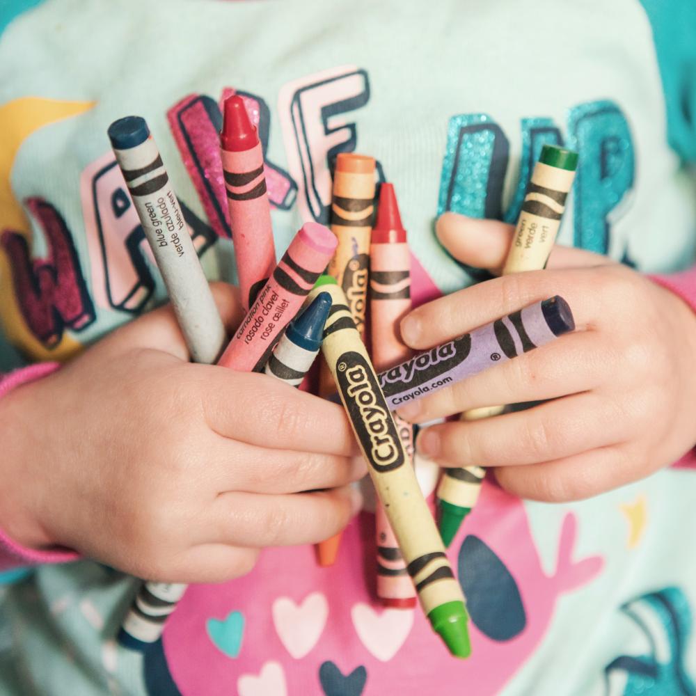 child holding crayons